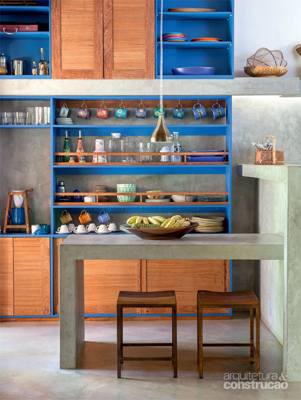A cozinha resgata o tom azul das esquadrias. De resto, os armários exibem portas de angelim-pedra. Projeto de Amadeo Romero.