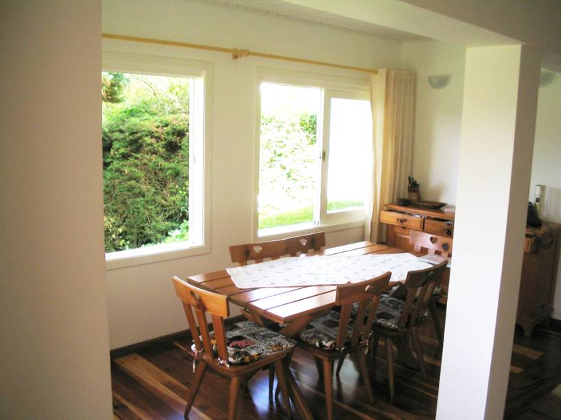 CASA EM CAMPOS DO JORDÃO. Na parte interna da casa, o destaque é a sala de jantar. Com 30 m², o ambiente, projetado por Luiz Rego Freitas, é integrado ao salão de jogos e à cozinha. O piso é de réguas de madeira (Maracatiara, com aplicação de resina acrílica fosca).
