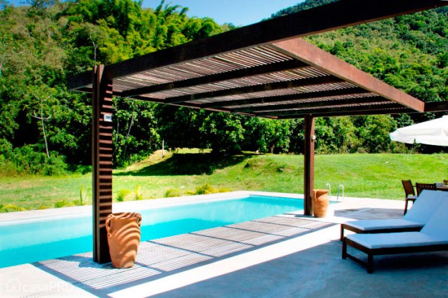 Pergolado filtra a luz, produzindo agradável sombreamento sobre parte do deck da piscina. Projeto de Eliete Nemy Mourão.