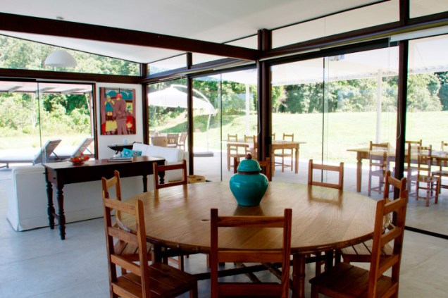 Envidraçada, esta sala de jantar se comunica com a paisagem e aproveita ao máximo a iluminação natural. Projeto de Eliete Nemy Mourão.