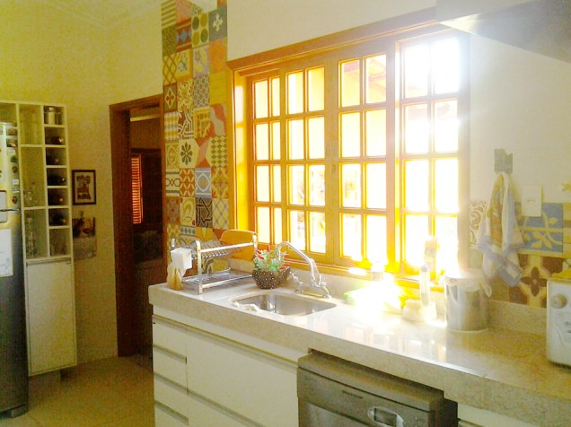 CASA EM MINAS GERAIS. A cozinha da casa projetada por Cláudia Breias tem 20,30 m². O ambiente traz bancada em granito branco (Itaúnas), porcelanato no piso (Modern Pastel, Portobello, 60x60) e patchwork de ladrilhos hidráulicos (Ladrilhos Barbacena, 20x20).