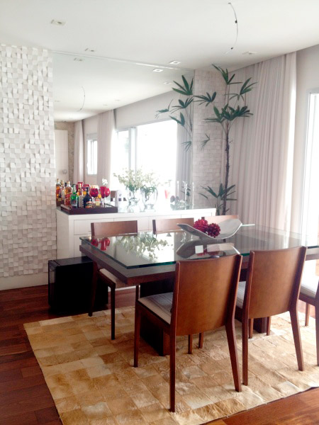 Esta sala de jantar conta com buffet, adega e espelho. O tapete dá o toque de aconchego. Projeto de Adriana Victorelli.