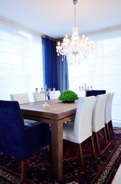 Azul e branco compõem esta sala de jantar sofisticada. A decoração é arrematada com um tapete e um livro. Projeto de Marli Lima.