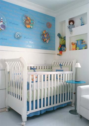 Na parede do berço, discos de vidro com desenhos sobrepõem-se à pintura azul decorada com adesivos que mostram o nome do dono do quarto. O projeto é de Anrriete Albuquerque e Juliana Lemos.
