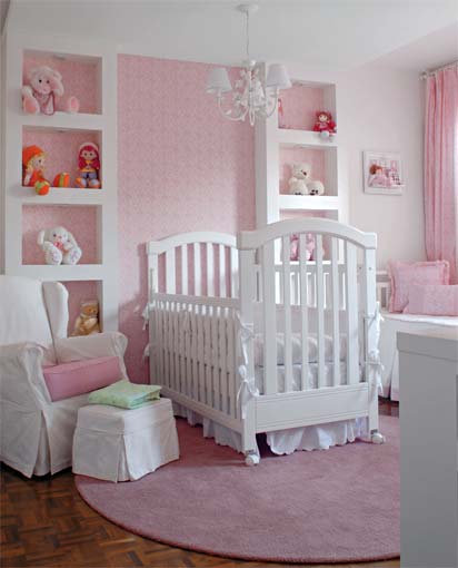 Com o berço, a cama e a poltrona de amamentação em branco, uma estampa de tecido rosa foi eleita para evocar o clima acolhedor e romântico ao ambiente. O projeto é de Deborah Roig.