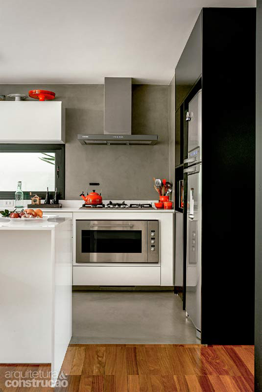 Para delimitar a cozinha e conferir unidade ao conjunto, o piso e as paredes receberam Tecnocimento, da NS Brazil. Projeto das arquitetas Maria Cristina Martini e Suzana Barboza.