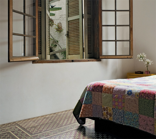 No andar superior, a cozinha virou o quarto do casal, que herdou os ladrilhos...