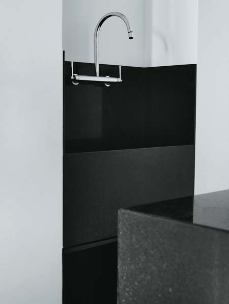 Como a lavanderia fica integrada à cozinha, o tanque de granito preto são g...