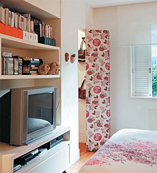 10. Dividida em três folhas, com fechamento tipo camarão, a outra porta que dá acesso ao closet, junto à estante da suíte, ganhou o mesmo acabamento de tecido sobre o compensado de madeira (também coleção Mocha). Projeto de Renata Bartolomeu.