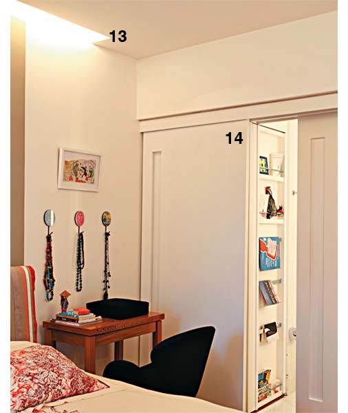 13. O rasgo de 20 cm de largura entre a parede da cabeceira e o rebaixo de gesso, no teto, embute a iluminação indireta e aconchegante. 14. A porta dupla, com acabamento de esmalte fosco branco, que liga o banheiro à suíte está presa a um trilho apenas na parte superior e tem puxadores discretos, cavados na marcenaria. Uma das folhas é versátil. Ela tanto fecha o banheiro como, se deslocada, esconde o armário de toalhas e roupas de cama no canto. Projeto de Renata Bartolomeu.