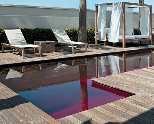 Inteira vermelha, a piscina tem mosaicos de vidro (ref. 3950, Vidrotil) e rej...