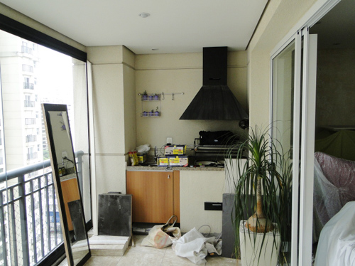 Varanda antes. A varanda localizada em um apartamento de 250m2, em São Paulo, tinha uma churrasqueira jamais usada e era um ambiente praticamente esquecido. Por isso, a designer de interiores Rose Ferraresi propôs à proprietária um ambiente clean e que se tornasse um canto aconchegante para descanso.