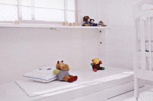 Este quarto de bebê foi pensado para receber ocasionalmente a babá: um nicho de marcenaria sob a janela guarda a cama, que fica embutida quando não está em uso. Com 25 cm de profundidade, o parapeito abriga uma prancha de MDF laqueado com pés embutidos de 10 cm de altura e colchão. O projeto é assinado por Marília Brunetti de Campos Veiga.
