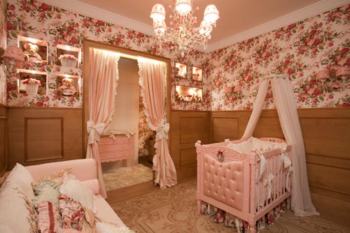 Assinado por Cláudia e Daniela Lopes, esse quarto abusa das flores: nos estofados, na roupa de cama, no tecido colado na parede e até no lustre! Segundo as profissionais, o ambiente faz uma releitura do estilo provençal, além de aliar o tema floral aos tons pastéis e à madeira utilizada nos móveis. O ambiente foi dividido em duas áreas, com fronteira demarcada por banho de luz na cortina. Na primeira, há o berço, a poltrona de amamentação e o sofá. Na segunda, a banheira, trocadores e o closet do bebê. O piso, térmico e de fácil limpeza, foi escolhido por ser o mais indicado para quartos de bebês. Nichos vazados dão leveza ao ambiente e auxiliam na circulação de ar.