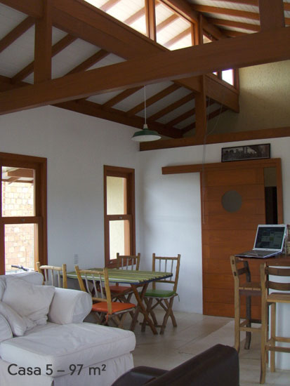 Projetada como um loft, a casa tem os ambientes sociais integrados: cozinha, sala de jantar, estar e home office dividem a mesma área. “Como não temos filhos, quisemos uma casa prática e pequena, que não desse muito trabalho”, conta Rosane. O pé direito elevado com um grande rasgo de vidro garante a iluminação natural e a ventilação dos espaços.