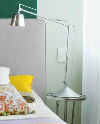 Sobre a mesinha lateral cromada (Ana Luiza Wawlberg), a lumin&aacute;ria de leitura...