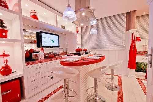 CASACOR Paraná - Hall e Copinha, por Renata Rosa Sguario. O ambiente tem a intenção de mostrar às crianças que utilizar ingredientes diferentes e formar uma receita é uma experiência incrível. No hall, a profissional criou uma área lúdica, com aquários de tintas e pequenos pés e mãos carimbados nas paredes para que os visitantes entrem no clima da brincadeira. Para garantir a segurança, os eletrodomésticos usados foram desenvolvidos especialmente para crianças, como o fogão eletrostático que funciona por indução.