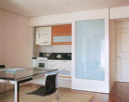 5 m&sup2;: A decis&atilde;o veio r&aacute;pido: o ponto de partida da reforma seria eliminar a parede entre sala e cozinha. Essa configura&ccedil;&atilde;o &eacute; mais pr&aacute;tica, e perfeita para conseguir amplitude, justifica a arquiteta paulista Consuelo Jorge. A propriet&aacute;ria n&atilde;o se preocupou em igualar os pisos: quis o conforto da madeira no living e a facilidade de manuten&ccedil;&atilde;o das pastilhas cer&acirc;micas no ambiente vizinho. Criei unidade usando madeira cherry nos arm&aacute;rios, e, para minimizar a variedade de acabamentos, repeti as pastilhas nas paredes, explica Consuelo. Os pain&eacute;is corredi&ccedil;os, de MDF pintado de branco e vidros serigrafados, servem para delimitar as &aacute;reas, mas raramente s&atilde;o fechados  a integra&ccedil;&atilde;o conquistou a moradora.
