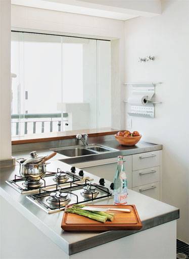 7 m&sup2;: Compacto e completo. Assim deveria ser este ambiente em S&atilde;o Paulo, planejado pelos arquitetos Francisco Guedes e Shisha Kess in. Acomodados em 2 x 3,50 m, geladeira, forno a g&aacute;s, microondas e fog&atilde;o cooktop fornecem tudo do que a moradora precisa tanto no dia-a-dia quanto nas ocasi&otilde;es em que cozinha para os amigos. Na gin&aacute;stica operada, sobrou espa&ccedil;o at&eacute; para uma &aacute;rea de servi&ccedil;o. A lavanderia ficava entre a parede atr&aacute;s da pia e a sacada do apartamento. Mas, como a cliente queria aquele canto livre para encaixar uma churrasqueira, o jeito foi embutir lavadora e secadora de roupas em um arm&aacute;rio, diz Shisha. O tanque fica na bancada logo ao lado.