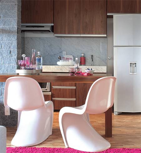 Parede de pedra miracema, tacos de am&ecirc;ndola e acess&oacute;rios rosa, uma das cores preferidas da propriet&aacute;ria, d&atilde;o o tom a este espa&ccedil;o onde a cozinha ocupa apenas 4 m2.