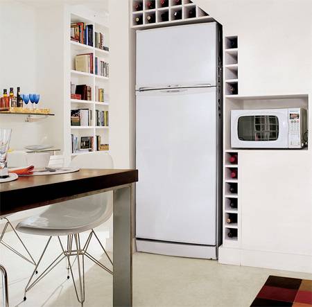 No v&atilde;o sob a escada ficam o refrigerador, nichos de MDF para o microondas e uma colm&eacute;ia para vinhos.