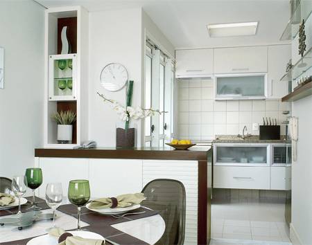 O balc&atilde;o de imbuia e madeira laqueada, que separa a cozinha da sala, &eacute; usado dos dois lados para guardar a lou&ccedil;a.