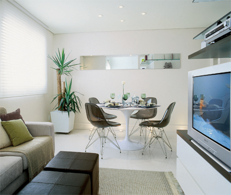 O piso de porcelanato branco, em placas de 60 x 60 cm, garante um visual requintado que ganha reforços com clássicos do design.