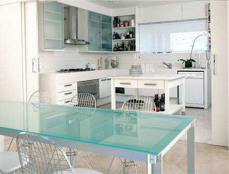 Quando &eacute; preciso, uma porta de correr isola a cozinha do jantar. O cimento queimado ocupa cada cent&iacute;metro do piso deste apartamento, sem excessos nem toques de cor, assim, estar, jantar e cozinha ficam totalmente integrados.