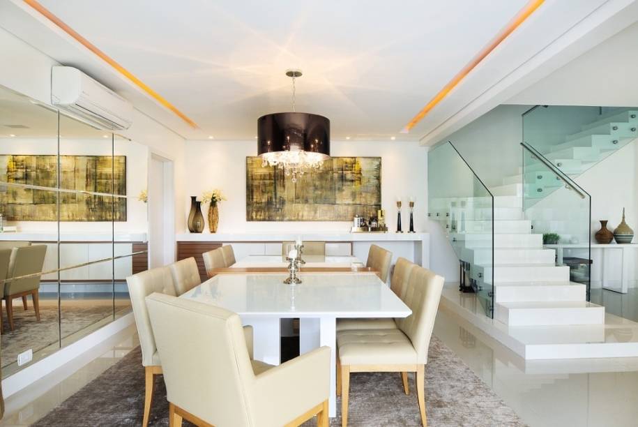 O piso em porcelanato marmoglass off-white dialoga com o lustre de cristal com cúpula em acetato metalizado na cor bronze nesta sala de jantar de 25 m² de uma residência em São Paulo. “Utilizamos materiais de tons neutros, mas para não deixar as salas como ambientes frios, usamos toques de madeira e objetos que refletem luz, como espelhos e vidros”, contam a arquiteta Melissa Corbett e a arquiteta e designer de interiores Daniela Gauch, que assinam o espaço.