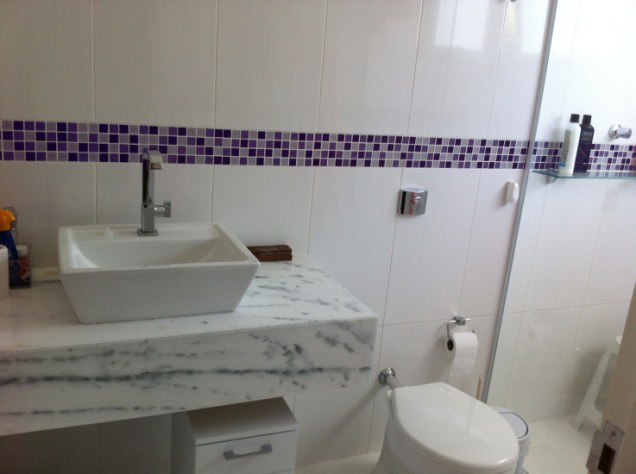Neste lavabo, o colorido fica por conta das pastilhas de vidro, nas tonalidades violeta e lilás. Com dimensões de 1,5 x 2,9 m, o espaço foi projetado pela arquiteta e urbanista Daniela Toledano para uma residência em Conchal (SP).