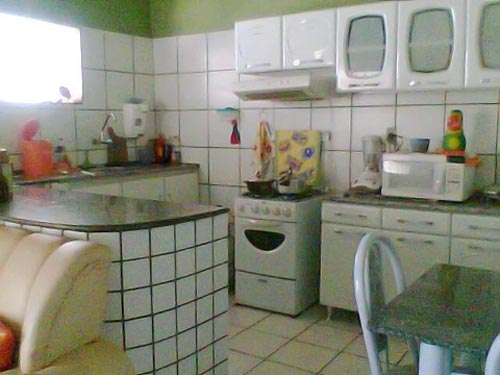 Carla, existe uma lenda de que rejunte escuro não junta sujeira. Realmente, o que já parece sujo não ficará mais sujo ainda. Cerâmicas devem receber rejuntes de sua própria cor. Renove seu rejunte para cores compatíveis com as da cerâmica. Utilize prateleiras para receber seu microondas e objetos decorativos. Existem kits prontos nas lojas. Coloque uma cortina clara na sua janela. Sua cozinha ficará mais ampla, mais limpa e sua bancada mais organizada.