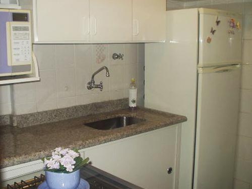 Bete, você resolveu muito bem sua pequena cozinha. Tudo no seu lugar dentro das possibilidades: armários brancos, prateleira para micro e porta de correr no armário da pia para não bater no fogão. Parabéns!