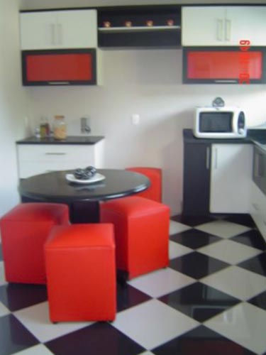 Singela, gostei da ousadia! Sinceramente, nunca havia imaginado pufes em uma cozinha. Gostei! Mas tá faltando uma prateleira para o microondas. Coloque lá no canto esquerdo do fogão. Ficará próximo à mesa, bom para esquentar pratos rápidos. Sua bancada ficará livre e parecerá maior.