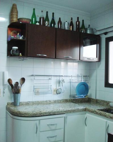 Ma, armários com rodízios são sempre bem vindos quando projetados racionalmente, como no seu caso. As garrafas em cima do armário o deixam parecendo um boteco! Garrafas de bebidas merecem uma prateleira fechada para elas ou um cantinho, como um bar lá na sala. Se você quer decorar lá em cima, utiliza potes decorados com cereais em seu interior. Vai ficar bem romântico e com cara de cozinha.