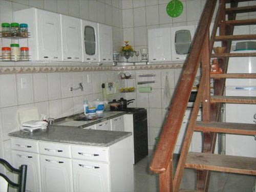 Monecris, eu nunca faria em meus projetos, um fogão apertado em um cantinho como o seu. Não sei como está seu dia-a-dia, mas ao fazermos um projeto de uma cozinha observo o seguinte sobre fogões:- tem que ter espaços livres nas laterais. Nada de colocá-los nas paredes, geladeiras ou laterais de armários;- em cima do fogão, somente coifa ou depurador. No seu caso, está contra todas as regras. Imagino que você tenha trabalho em limpar gordura na parede, na prateleira de vidro a cima do fogão e porta-temperos. Eu mesmo não caberia em baixo à frete do seu fogão. Mas também imagino que essa foi a alternativa que a construção lhe deu. Se um dia quiseres reformar sua cozinha, troque a posição do fogão com a da pia, deixando ele próximo à bancada em L e a pia ao lado da parede dos fundos. O fogão estará mais arejado desta maneira. Tenho certeza que cozinhar será um ato mais prazeroso.