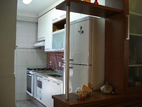 Denise, discordo de você. Acho que não ficou bom essa sua divisão. O visual da cozinha esta ótimo. Desde o projeto ao puxadores quadrados. Toda branca com fundo em pastilha sobre a bancada. Mas este cantinho não esconde a lateral da geladeira e o tubo de sustentação da prateleira não me parece nada funcional. A foto não mostra muita coisa a respeito do seu cantinho de petiscos, posso estar sendo injusto com você, mas talvez se você o dividisse com mais prateleiras formando nichos ou até fechá-lo aumentando o aproveitamento do móvel para sua sala.