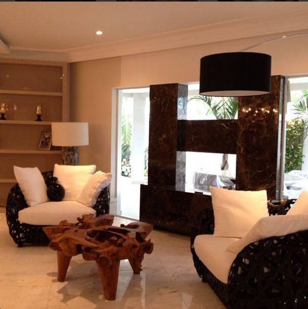 Um lounge foi criado para abrigar a lareira, no projeto desta residência no Rio Janeiro (RJ), assinado pela designer de interiores Flavia Campos. “Primeiro demolimos uma parede para a integração entre varanda e sala de estar. Depois, projetamos uma alvenaria baixa que pudesse ser a base da lareira. Uma painel de vidro foi aplicado nas laterais para que houvesse integração visual entre os espaços”, explica a designer. Revestida de mármore marrom imperial, a lareira funciona à base de biofluido.