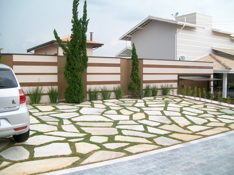 Quando o cliente resolveu comprar o terreno ao lado desta casa em Valinhos (SP) para construir a área de lazer, o escritório de arquitetura idEA. optou por um revestimento que imita madeira – material amplamente utilizado na parte que já estava construída. Para dar um charme a mais na fachada, os espaços em “V” no muro abrigam pinheiros, que não atrapalham as vagas de carros. A estrutura também serve para evitar que a Luna, labrador dos moradores, não escapasse. O piso externo é composto de pedra São Tomé com gramas nos vãos.