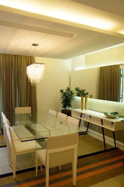 A sala de jantar possui 18 m² neste apartamento de um homem solteiro em São Paulo (SP). “A ideia foi deixar uma base bem leve e colocar as cores nas peças mais fáceis de serem substituídas, como cortinas e tapetes. Se o cliente enjoar das cores, em poucos passos, consegue criar um novo ambiente”, explica a arquiteta Juliana Matos, que assina o espaço. Para isso, tons neutros como bege e preto foram escolhidos para a base e tons vibrantes, como laranja, nos adornos, como o tapete.