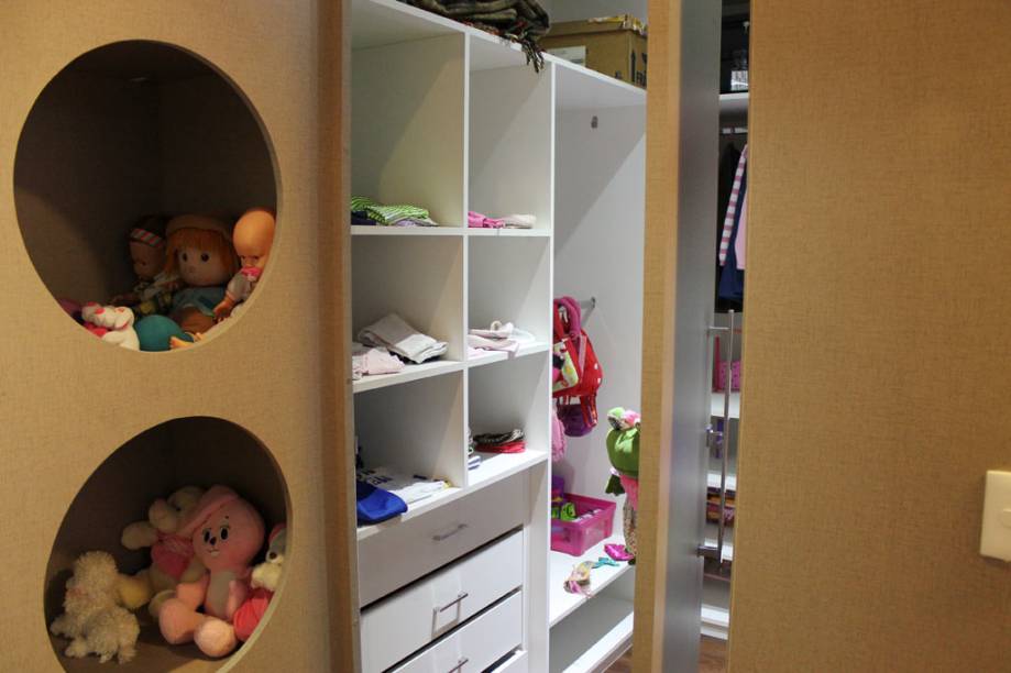 Neste quarto de 16 m² para uma criança de oito anos, o closet ocupa 4,3 m², mais de um quarto do espaço total. O material escolhido foi MDF branco e amadeirado devido à resistência e ao preço. Já a iluminação é composta de lâmpadas de LED dricrócia e PAR 20. “Elas realçam as cores das roupas e trazem aconchego para o closet”, explicam os arquitetos da L’arki arquitetura. O espaço pertence à uma residência em Jundiaí (SP).