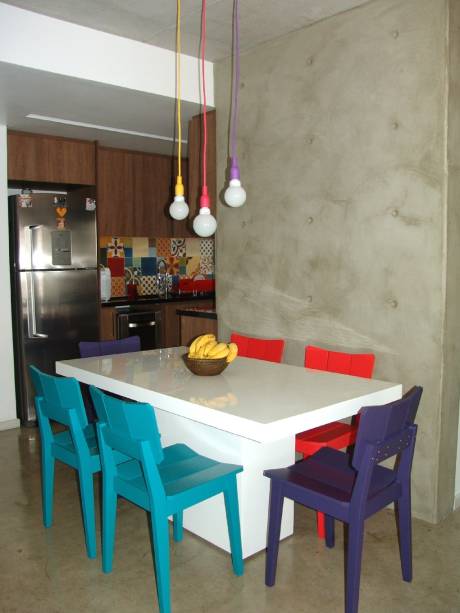 Neste apartamento em São Paulo (SP), piso, parede e teto vieram com acabamento de cimento queimado da construtora. Então, as arquitetas Ana Carolina Lima Orsolini e Mariana Lima Orsolini optaram por trabalhar com cores ousadas nos móveis e acessórios. Ao todo, o espaço tem 9,40 m².