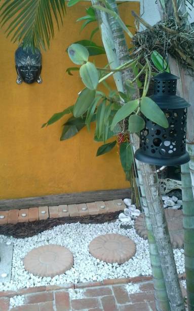 No jardim externo desta casa em Praia Grande (SP), os tijolos receberam uma camada de silicone líquido para mantutenção do material. Pedriscos, palha natural de palmeiras e buritis também compõem o espaço de 8 x 3,75 m. O projeto é assinado pela arquiteta Luciane de Araujo Keskissian.