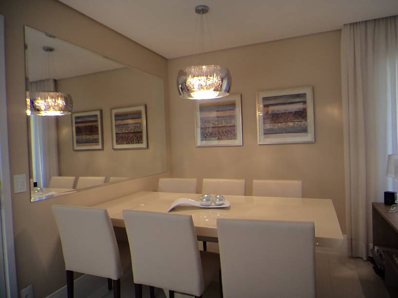 Mesa de resina na cor pastel e cadeiras revestidas em linho compõem a sala de jantar de 10 m² deste apartamento em São Bernardo do Campo (SP). Porcelanato na cor diamante da Portinari reveste o piso e a parede ganhou a cor cocada da Suvinil. “Os materiais utilizados foram escolhidos para dar uma sinergia ao ambiente”, explica a designer de interiores Mara Santos, que assina o projeto.
