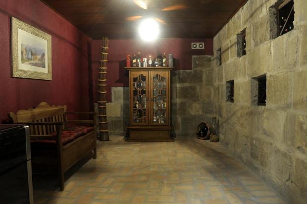 Os tijolos de barro maciço foram colocados neste espaço de 1,5 x 2,5 m para dar toque rústico. As pedras naturais, utilizadsa para a manutenção da temperatura do vinho, e a alvenaria, rebocada com pintura, complementam o ambiente. Já a parede ganhou pintura em tom borgonha, fazendo alusão à uva e ao vinho. O projeto é da arquiteta Melissa Bulla Baron para uma residência em Caxias do Sul (RS).