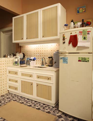 Integrada à sala, a cozinha do Pedro (Leonardo Bricio), de Chamas da Vida, é bem pequena, justamente porque ali mora uma família com poucos integrantes. O ponto de encontro deles não é a cozinha e sim a mesa de jantar. Simples, tem apenas o necessário para o dia-a-dia. Os armários foram desenhados pela cenógrafa Ana Paula Antunes Lopes e confeccionados pela equipe da Rede Record. Os demais móveis são do acervo da emissora.Credito: Leo Costa