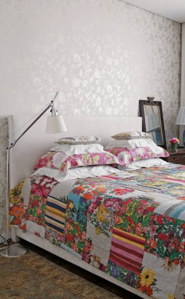 O fundo branco da cabeceira e do papel de parede, combinados aos móveis de madeira, permitem ousar nas estampas. A do papel (Miranda Green) combina com o floral da roupa de cama (Villa Nova). O quarto foi decorado pela designer de joias Brenda Vidal.