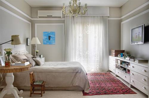 A designer de interiores Paola Ribeiro alinhavou com todo o cuidado a decora&ccedil;&atilde;o do espa&ccedil;o. Molduras brancas revelam uma leve inspira&ccedil;&atilde;o francesa e valorizam as paredes, tingidas em duas grada&ccedil;&otilde;es de um bege-acinzentado. "A ideia era dar ao quarto uma atmosfera rom&acirc;ntica", diz Paola.