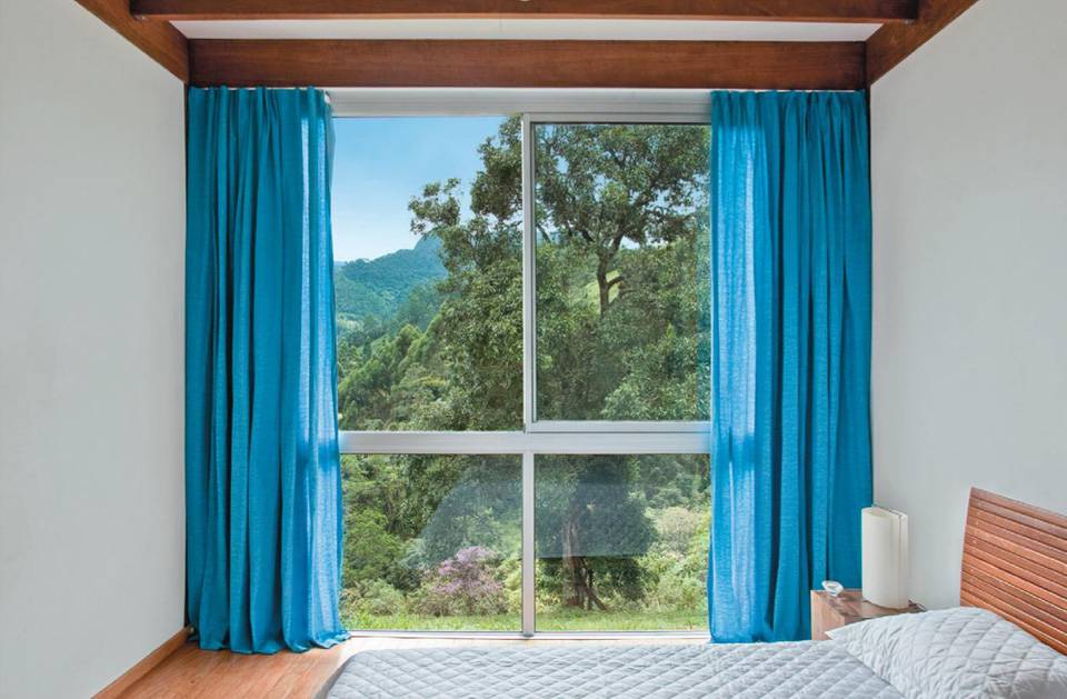 Os arquitetos Lua e Pedro Nitsche deram um toque de cor pouco tradicional neste quarto de base neutra: dispensadas as venezianas, entraram blecautes e as cortinas coloridas.