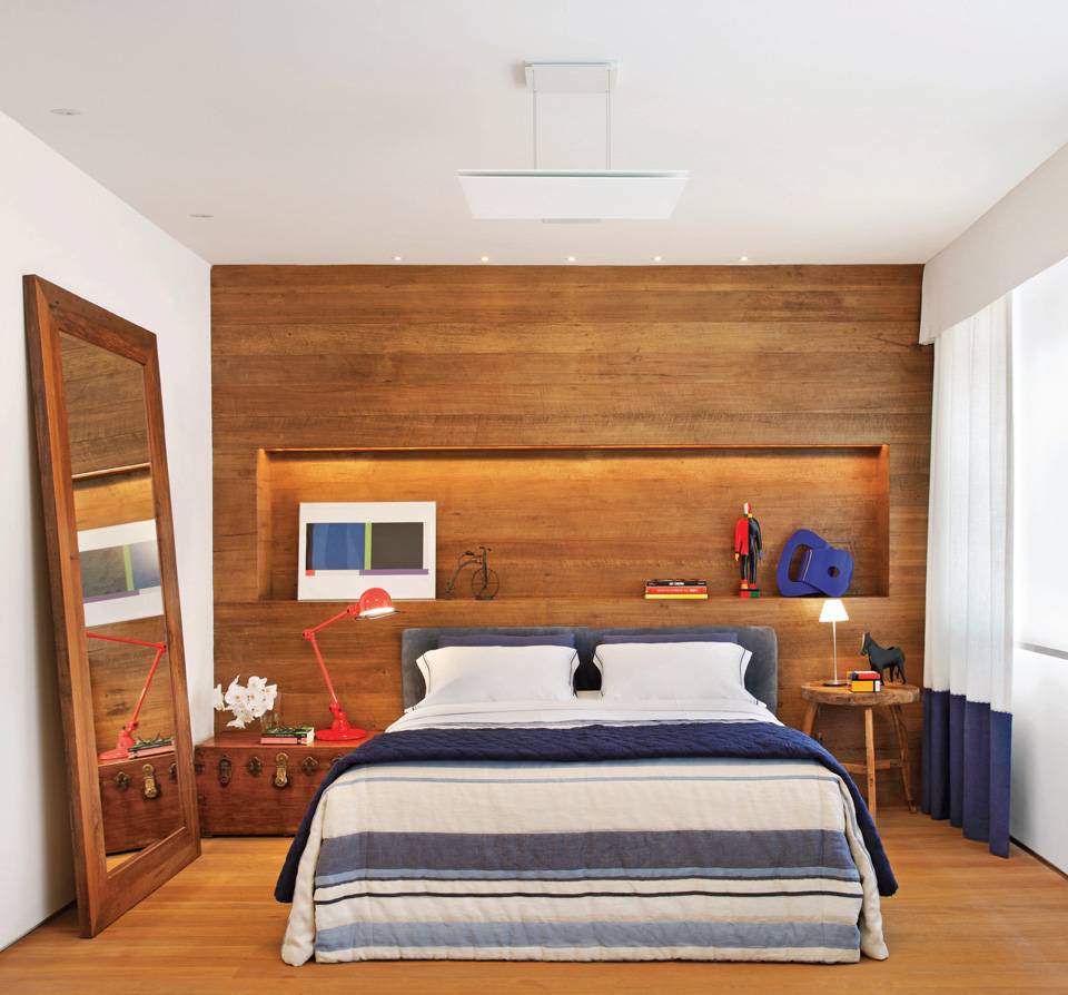 Neste quarto de 25 m2, projetado pelo arquiteto Luiz Fernando Grabowsky, o painel de madeira forma uma base neutra que permite mesclar cores em pequenos detalhes da decora&ccedil;&atilde;o.