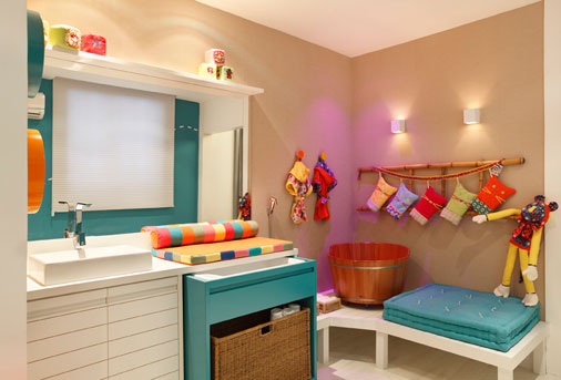 Um templo de relaxamento para os bebês! O espaço assinado por Nayara Macedo conta com um futon para a prática de Shantala, ofurô infantil, iluminado com controle romoto (LED) para a realização de cromoterapia e banheira móvel com rodízios embutida da Tinoc. A decoração segue o estilo do Quarto dos Bebês Gêmeos. As paredes foram revestidas de palha natural e o tapete é de sobras de EVA trançado. Na parede, uma escada de bambu substitui a marcenaria. Trocador e futon de algodão orgânico e revestimento de tecido 100% reciclado reforçam a tendência sustentável.